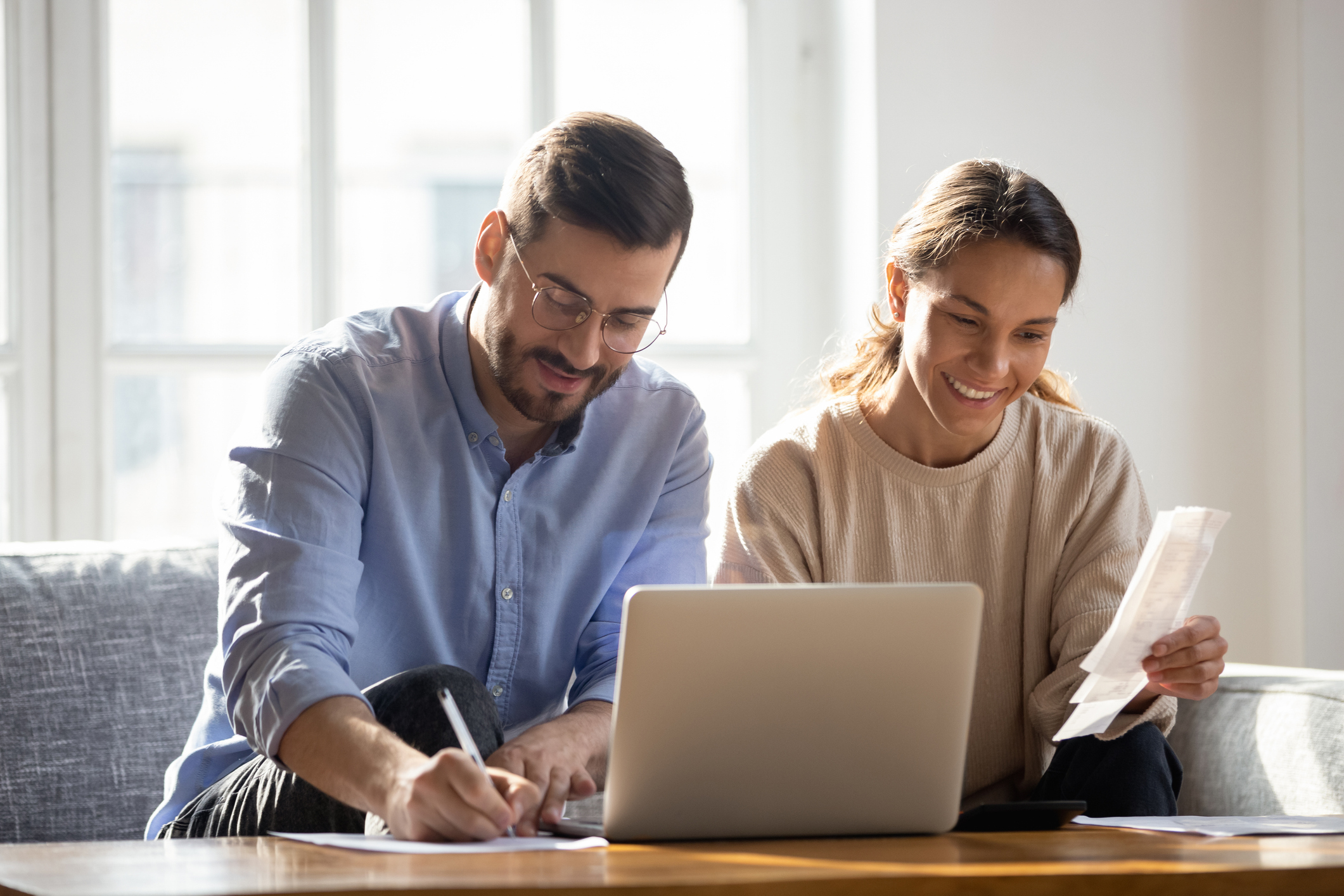 A couple looking at bills while assessing their finances